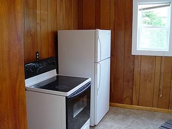 Kitchen is clean and ready for many meals with lots of cupboards.