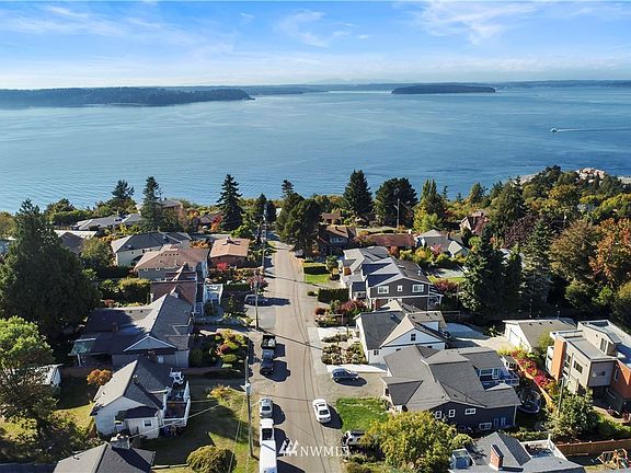 Hard to find shy quarter acre lot with circular driveway, 2 car detached garage and private backyard~Beautifully landscaped with attention to detail creates spaces for relaxing, playing and breathing in the salt air