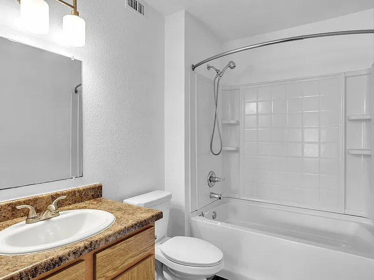 Modern bathroom design with a spacious white bathtub, elegant sink with contemporary countertop, and large mirror. Modern bathroom design with a spacious white bathtub, elegant sink with contemporary countertop, and large mirror.
