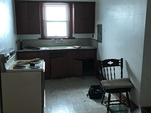 Kitchen has a refrigerator and a stove. I am in the process 
