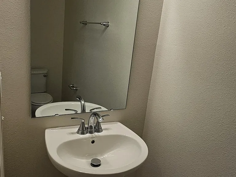 Convenient main-level powder room featuring a pedestal sink, modern lighting, and neutral finishes.