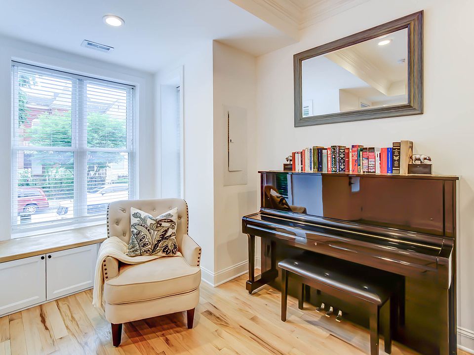 This view highlights the front window and charming built-in window seat with hidden storage, perfect for keeping shoes neatly tucked away just inside the entry.