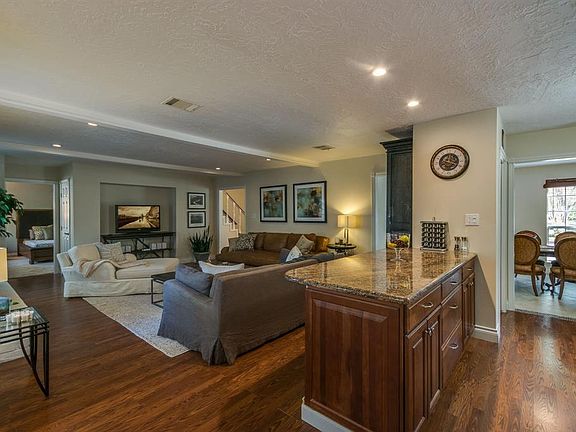 The den area is huge and is neutrally painted which makes decorating the space easy. Notice the granite counter top with plenty of cabinetry to serve your guests.