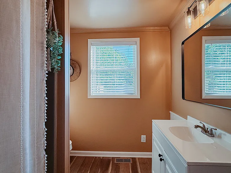 Second full bathroom with a large vanity, mirror, and bathtub