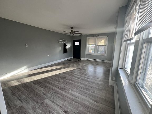 Spacious living room w/ coat rack and tons of lighting.