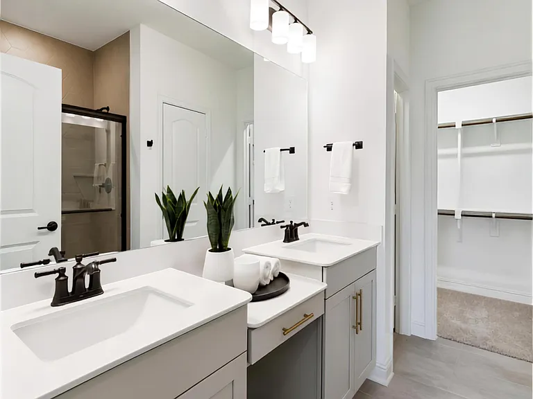Spacious bathroom with double-sink vanity, oversized mirror, and ample cabinet storage with updated lighting.