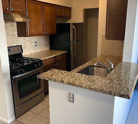Galley style kitchen- granite counters, stainless steel appliances