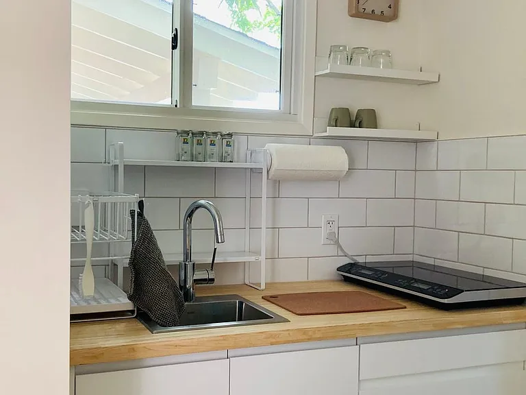 Kitchenette with dish drainer, burner, dishes and silverware, pots and pans (inside the drawers