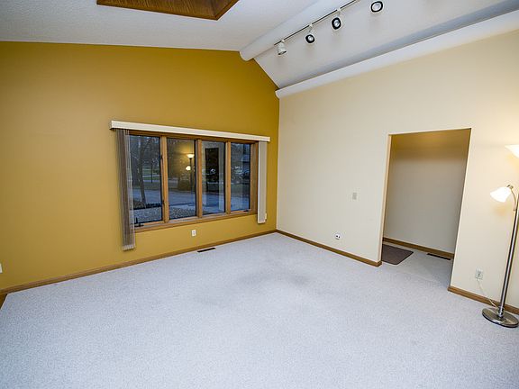 Through the front door and foyer (shown on the right side of this photo) is the living room (20x13).  Vaulted ceilings, two skylights, a wall of Andersen windows, and an open flow into the dining area make this large space bright and airy. 