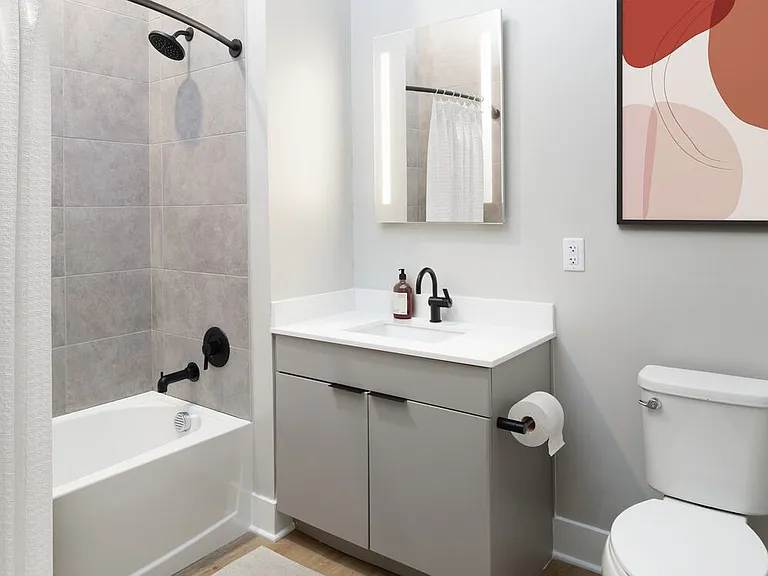 Signature Collection bath with LED vanity mirror, white quartz countertop, light grey cabinetry, and hard surface flooring