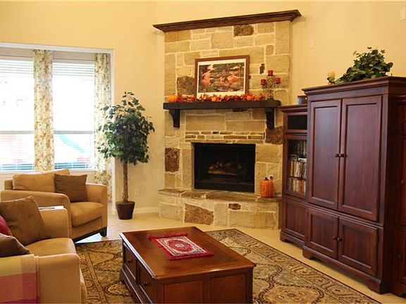 Bright open family room with stone fireplace and gas logs.