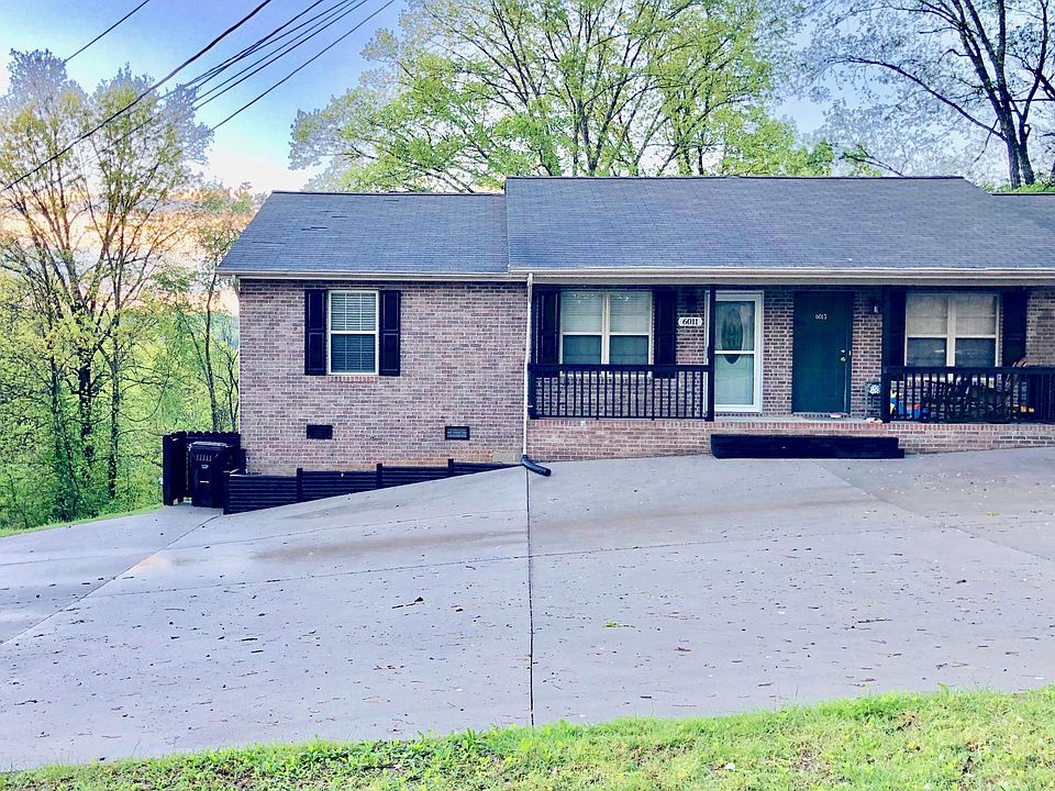 Front of property with large parking areas for multiple cars.