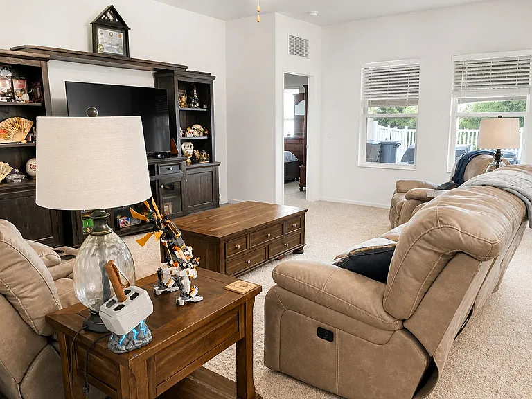 Spacious living room with plush seating, entertainment center, and large windows overlooking the deck for easy relaxing.