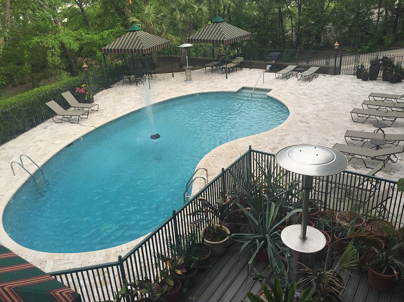 Porch overlooks pool and trees