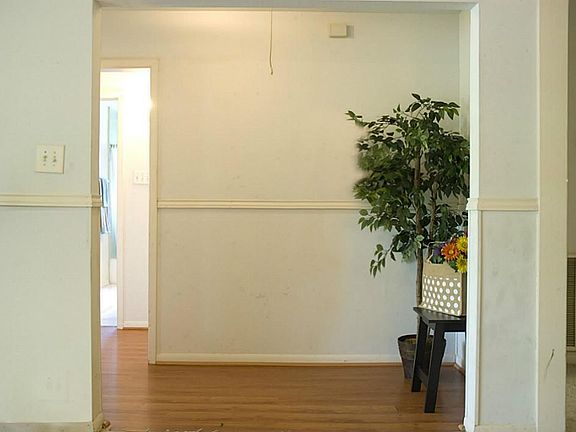 The entry with wood laminate floor also offers chair-rail molding.