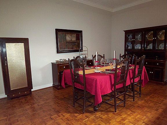 Dining room enhanced by parquet wood flooring, double crown molding, recessed lighting and access to the kitchen.
