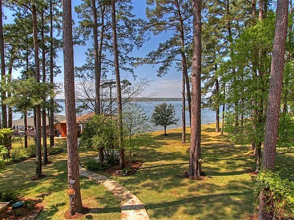 Stoned pathway to boat slip surrounded by mature trees and landscaping.