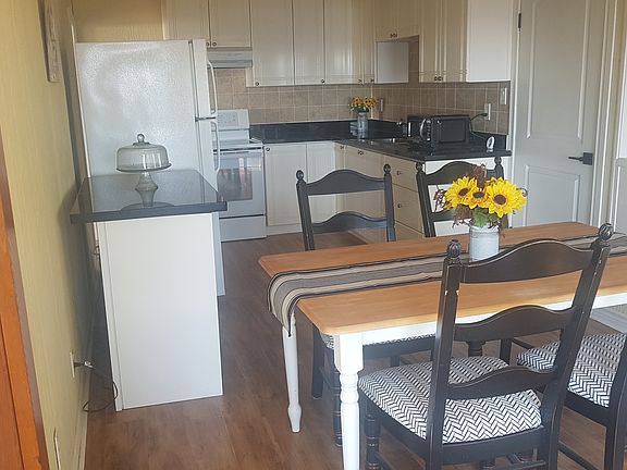 The Farmhouse Kitchen is fully equipped with stove, fridge, microwave and dining table with seating for four and a view of the lake.