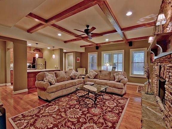Fully furnished living room looking to kitchen and bedroom access.