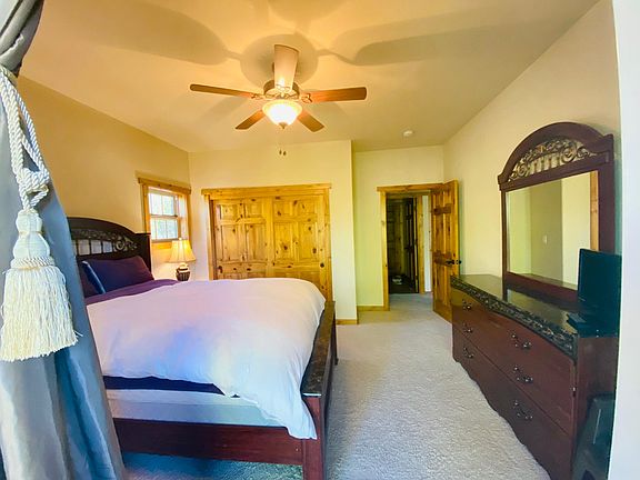 Downstairs guest bedroom one with a queen bed and balcony.