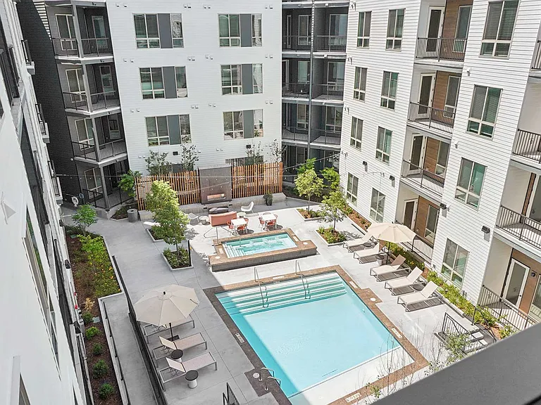 Cool off, unwind, or soak up the sun in a resort-inspired pool courtyard featuring lounge seating, landscaped gathering spaces, and modern outdoor design.
