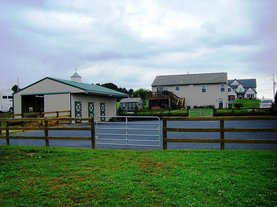 Rear Of Home With View Of Pole Barn And Riding Ring