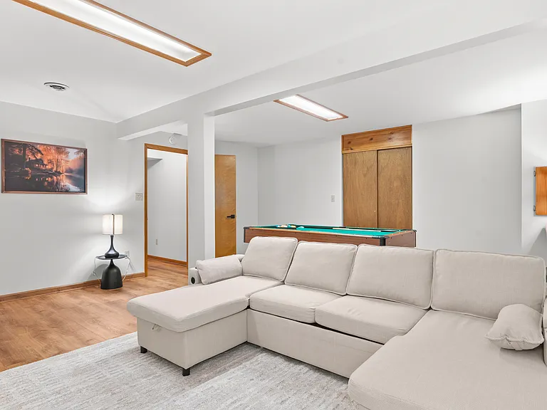 Flexible basement bedroom/lounge with a convertible sofa for comfortable seating or sleeping with pool table.