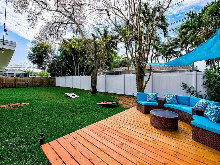 Fully fenced in backyard with fun lights for evening ambiance.