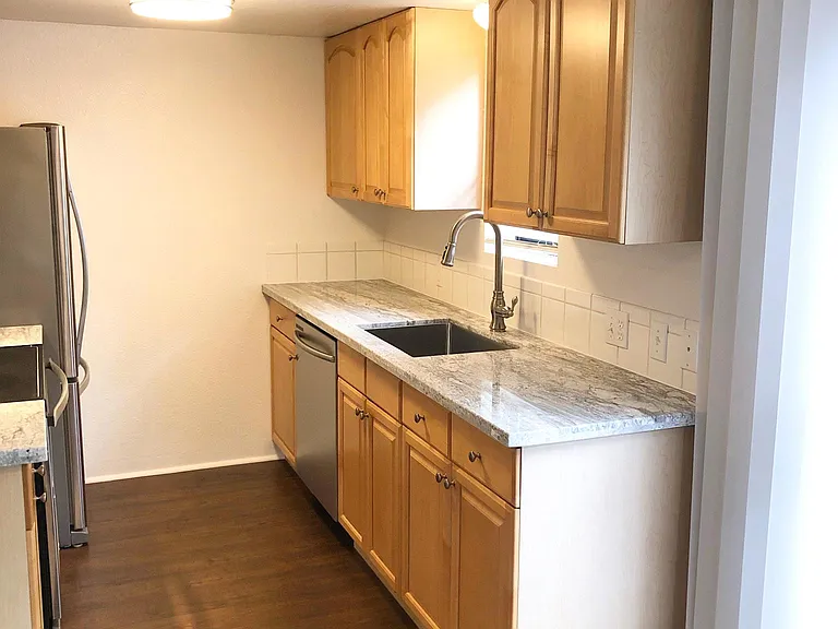 Kitchen with granite counters, deep sink and single lever faucet with pull out spray.