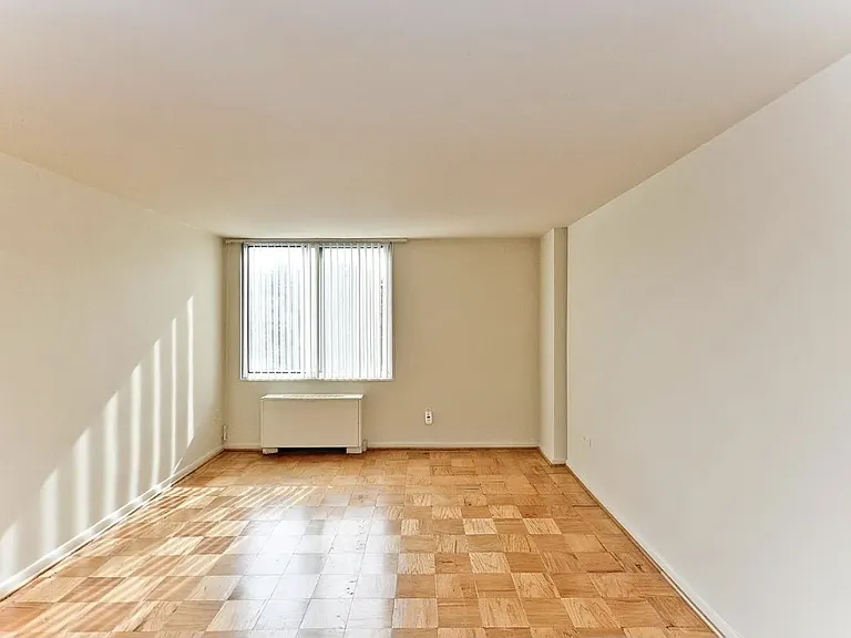 Second bedroom view with hardwood floors and warm sunlight.