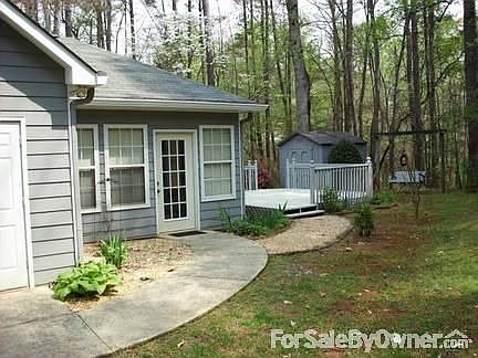 Right side of house : view showing walkway, storage room on side of house, small storage bld in back