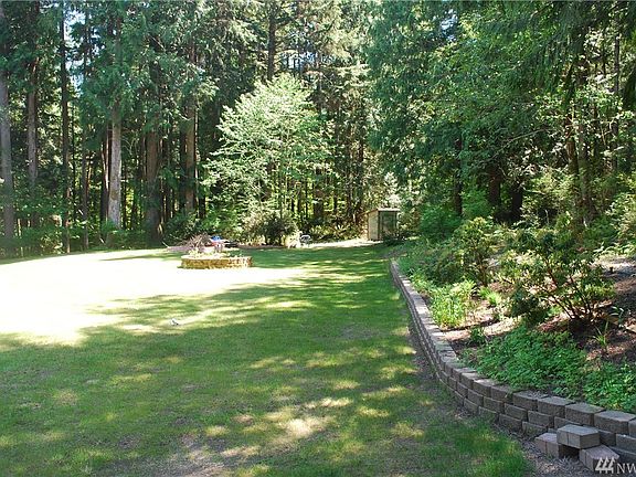The front yard, well house and yard over to the back yard.  Check out the sprinkler system throughout the front yard flower beds and around the circular driveway.