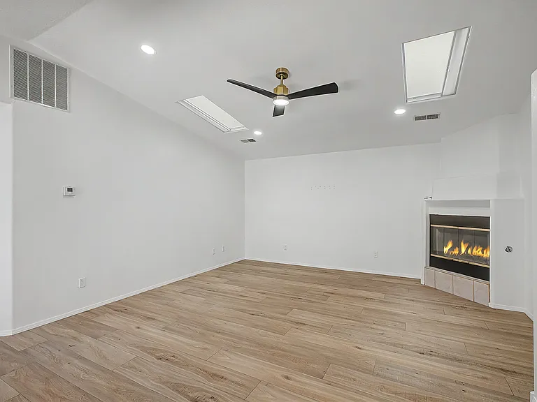 Living room with fireplace. Skylights for natural lighting.