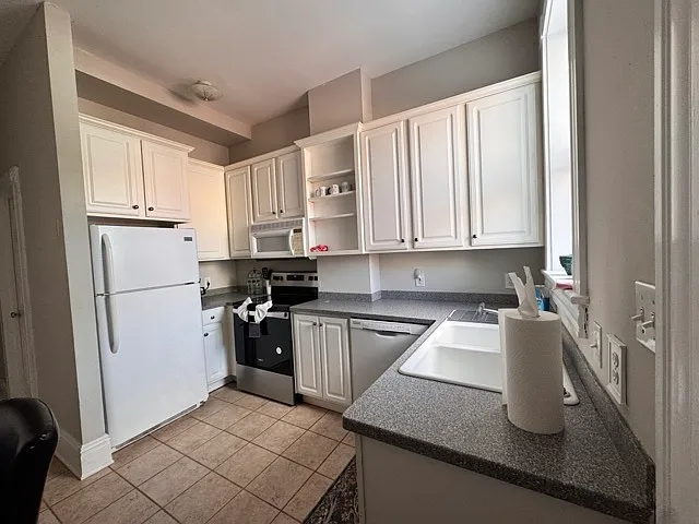 View of kitchen when you come in from the back door. Lots of cabinets to store groceries. Refrigerator, oven, coffeemaker, microwave, dishwasher and disposer.
