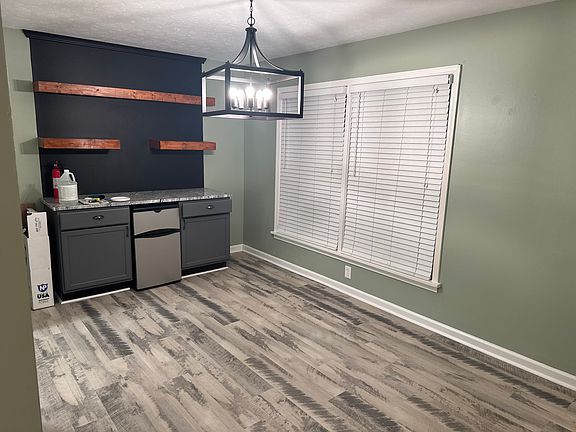 Dining room has shelving and mini fridge with counter space and storage