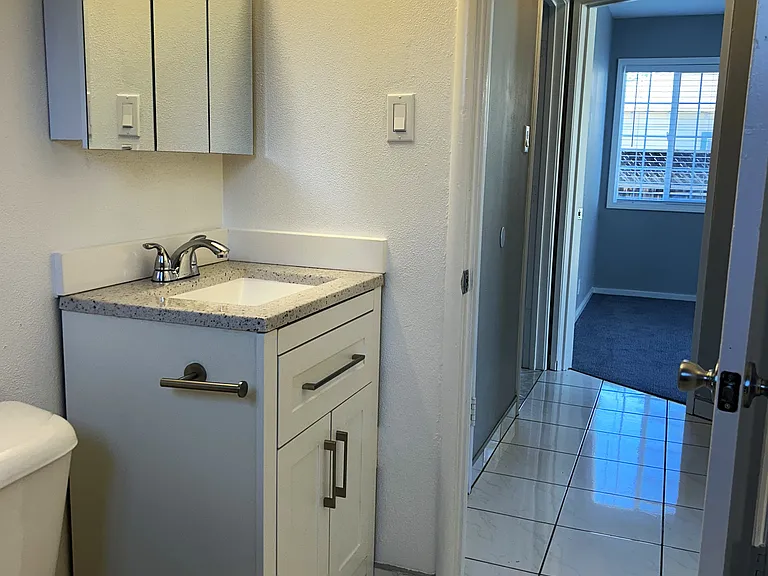 Updated bathroom with new vanity, medicine cabinet, and lighting.