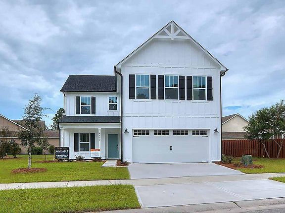 A white house with black shutters and a large garage.