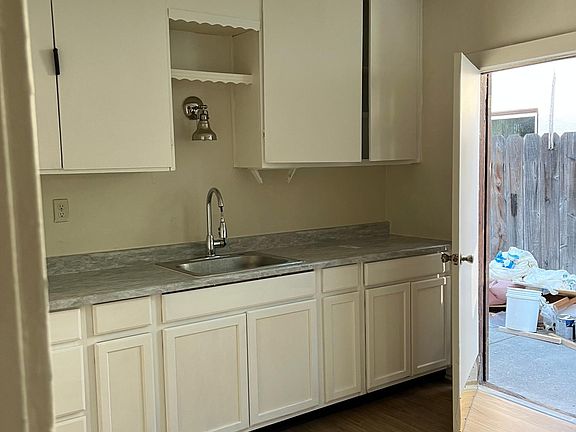 Kitchen: new countertop, sink, and cabinets. Door leading to private yard.