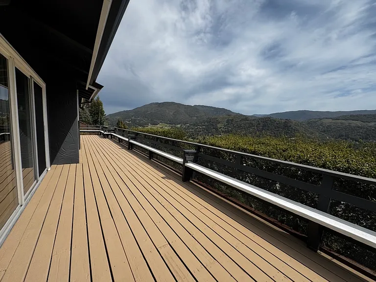 Upper-level wrap-around deck with 3 entrances, primary bedroom, living room & dining room.