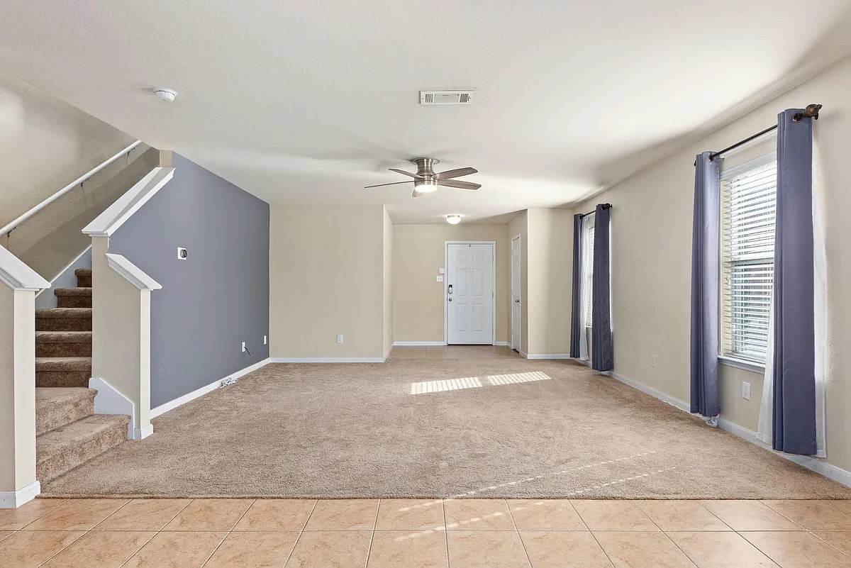 The spacious living area boasts neutral colors and plush carpet. - 9105 Sun Haven Way