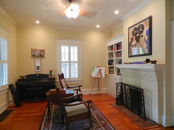 Bright and airy formal living room with re-built wood burning fireplace, recessed lighting, plantation shutters and beautiful re-finished heart of pine floors