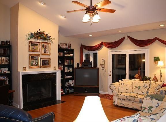Great Room features Hardwood Floors, Fireplace, and Spacious Screened in Porch