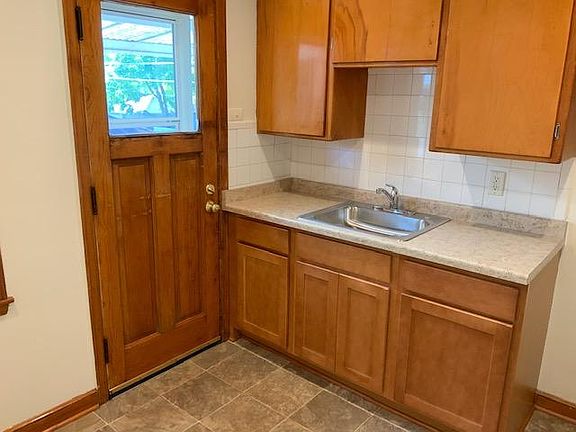 Kithen with new counters, sink and cabinets. View toward back door.