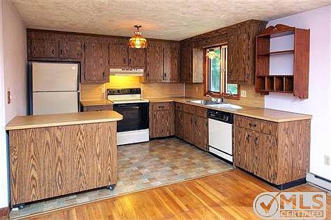 Kitchen with vinyl floor, movable island with storage below, and all appliances