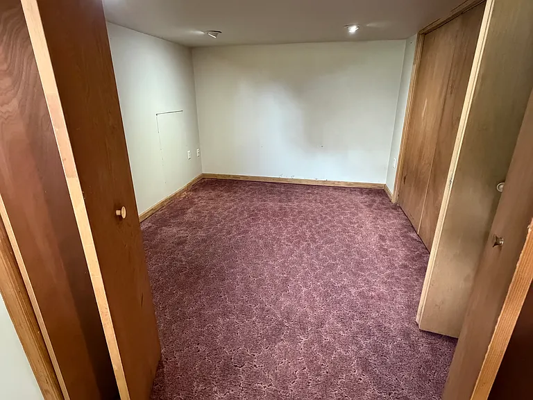 Bonus room in basement can be used as den, office, craft or exercise room. It has built-in ceiling lighting, a small closet, and is carpeted.