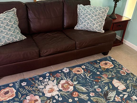 Living space with television inside large standing armoire. Comfortable sofa.