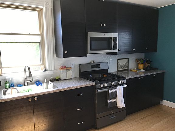 Kitchen with tile backsplash, modern slate colored appliances and Ikea cabinets.