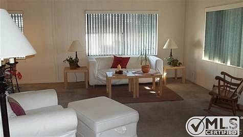 Lovely, carpeted, living room with vertical blinds and lots of natural light!