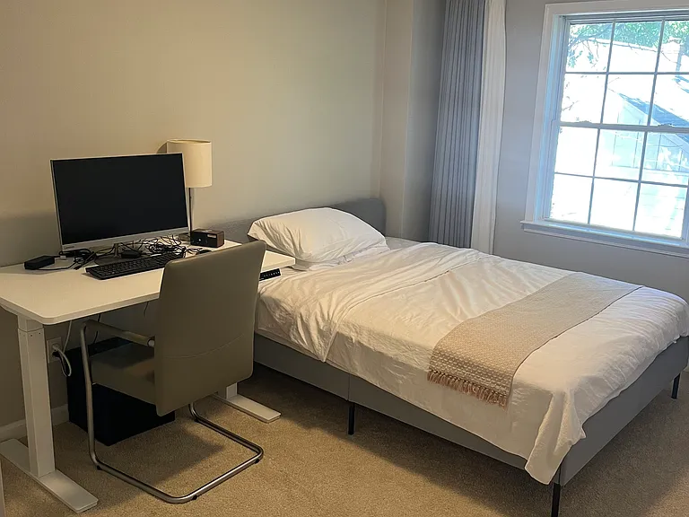 Second bedroom with a queen-size bed and an electric standing desk