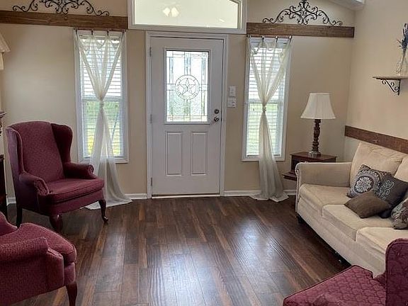 Living room is spacious and bright with laminate flooring and crown molding. Furniture not included. Property not furnished.